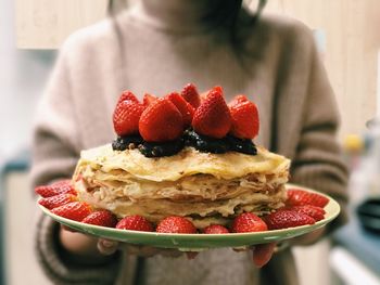 Midsection of woman holding dessert in plate