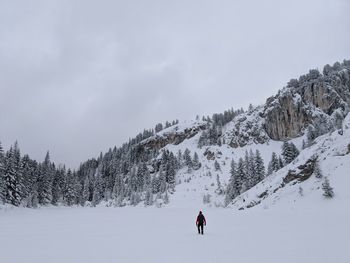 Person skiing on snow covered mountain against sky