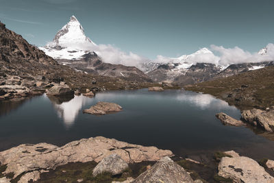 Scenic view of lake and snowcapped matterhorn against sky