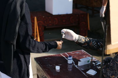 Cropped hand of woman applying ink on hand