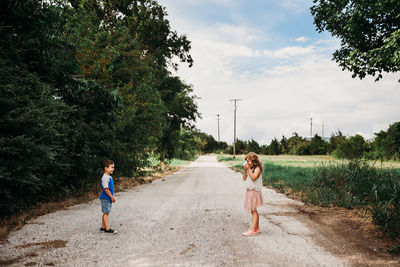 Young girl taking picture of brother with instant camera