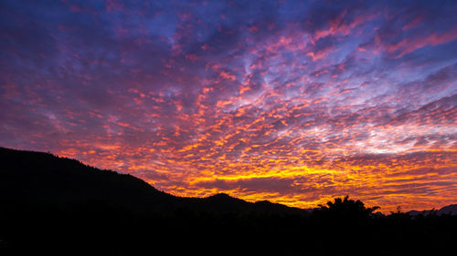 Scenic view of silhouette mountains against dramatic sky