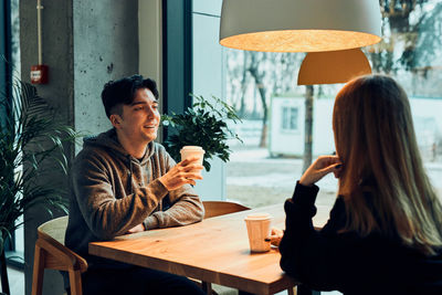 Friends having chat, talking together, drinking coffee, sitting in cafe. man and woman having break