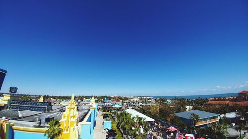 Panoramic view of people in city against clear blue sky