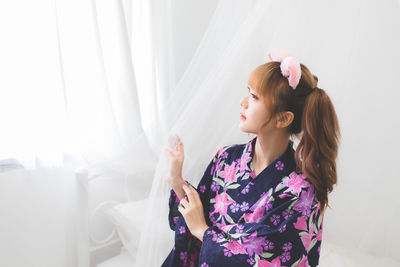 Young woman looking away at home