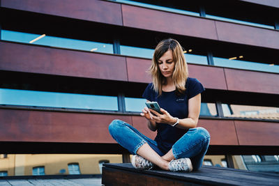 Woman using smartphone at city street