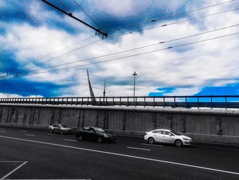 Cars on road against sky in city