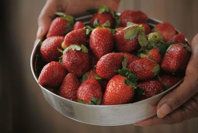 Close-up of hand holding strawberries