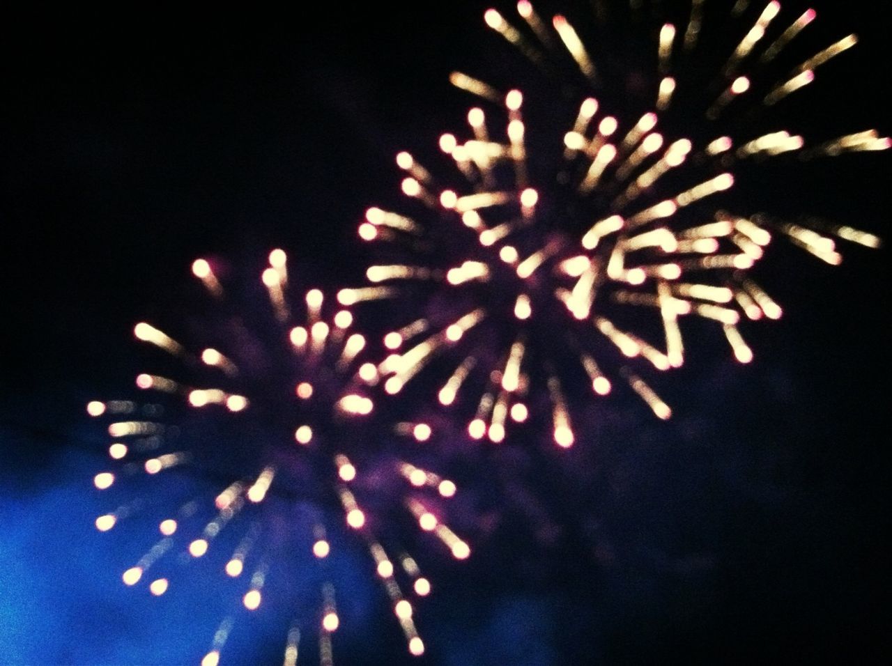 night, celebration, low angle view, firework display, exploding, sky, illuminated, glowing, arts culture and entertainment, firework - man made object, outdoors, event, no people, motion, close-up, clear sky, celebration event, long exposure, entertainment, beauty in nature