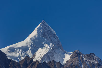 Scenic view of snowcapped mountains against clear blue sky