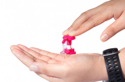 Close-up of hand holding toy over white background