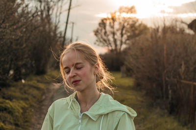Portrait of young woman standing on field