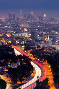 High angle view of illuminated city street and buildings at night