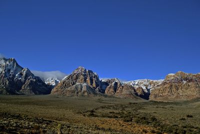 Scenic view of mountains against clear blue sky
