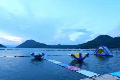 Boats moored in sea against blue sky