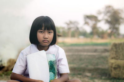 Portrait of girl sitting on field