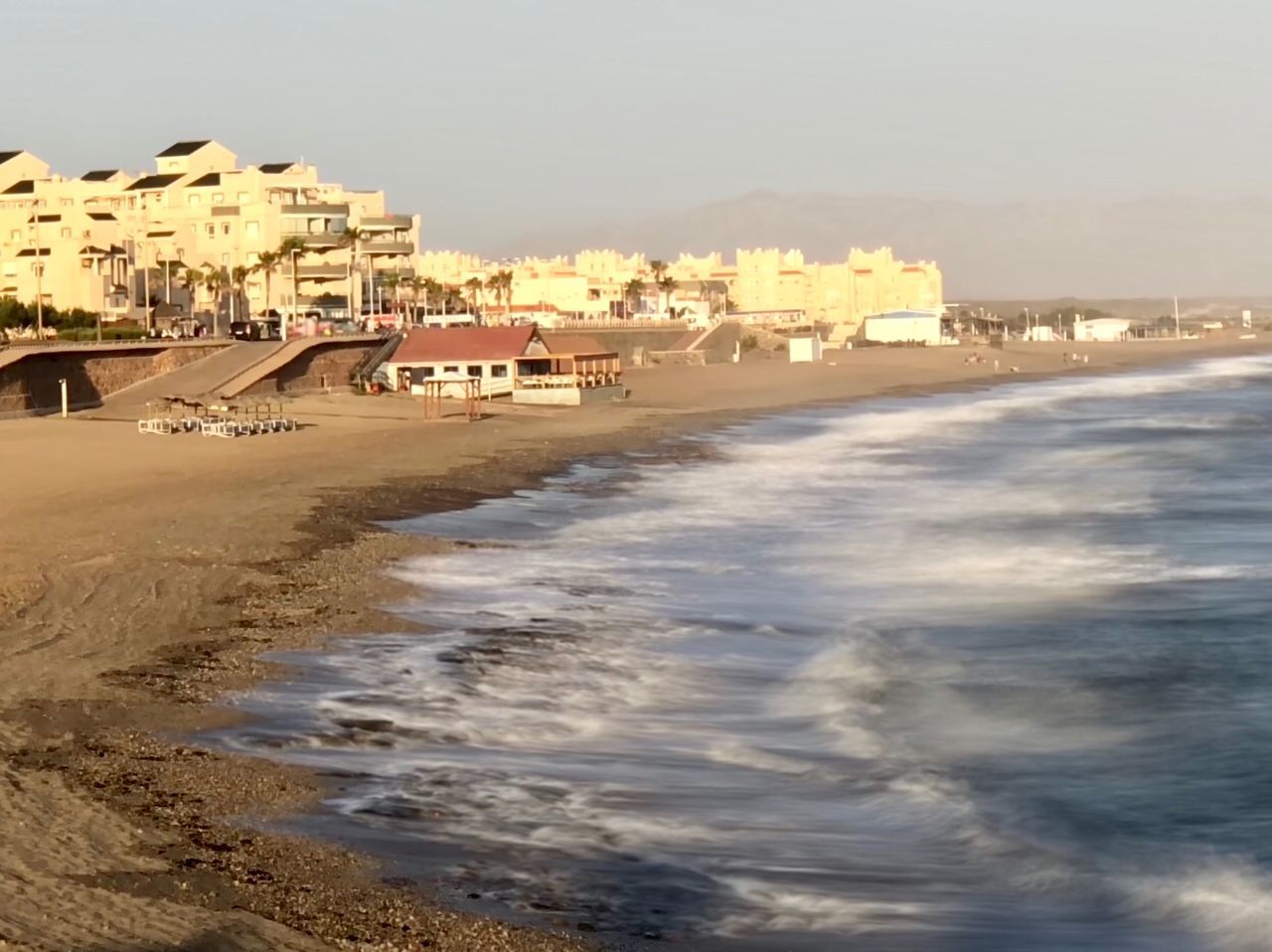 BEACH AND BUILDINGS AGAINST SKY DURING SUNSET