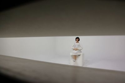 Young woman standing against wall