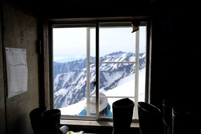 Scenic view of snowcapped mountains seen through window