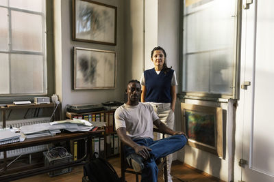 Portrait of confident male and female colleagues in workplace