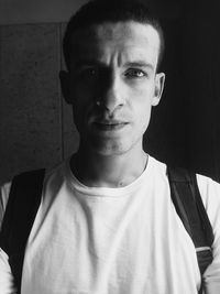 Portrait of young man standing against wall