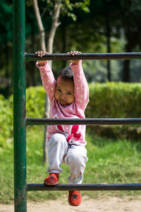 Cute girl climbing on outdoor play equipment