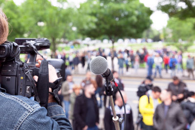 Cropped image of camera operator against crowd