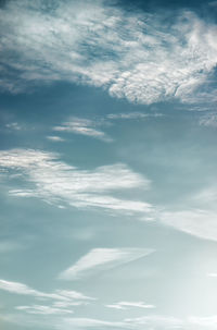 Low angle view of sunlight streaming through clouds