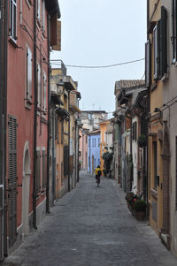 People walking on street amidst buildings in city