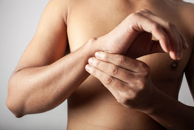 A young indian male touching wrist injury with pain. isolated on white background.