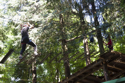 Low angle view of man jumping in forest