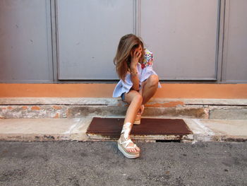 Full length of woman sitting on staircase