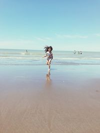 Full length of woman on beach against sky