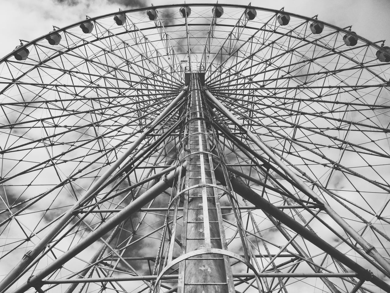 low angle view, amusement park, amusement park ride, ferris wheel, arts culture and entertainment, sky, built structure, architecture, metal, pattern, day, tall - high, outdoors, no people, tower, design, travel destinations, famous place, circle, tree