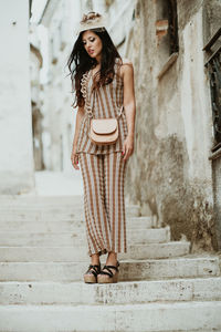 Portrait of woman standing against steps