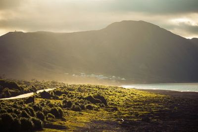 Scenic view of sea and mountains against sky