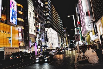 People on city street amidst buildings at night