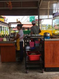 Rear view of people standing at market stall