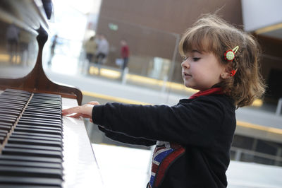 Cute girl playing piano in city