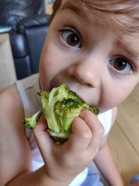 Close-up of boy eating broccoli