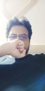 Portrait of young man wearing eyeglasses at home