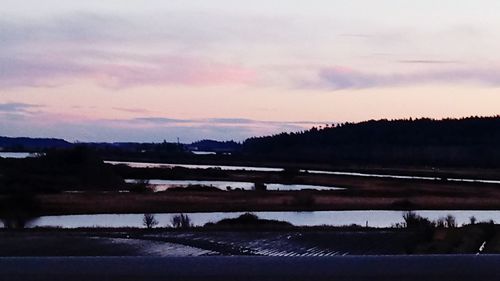 Scenic view of lake against sky at sunset