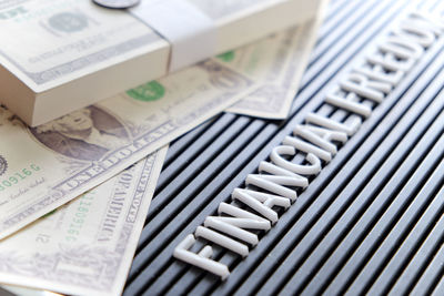 Close-up of text with money on table