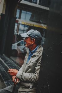 Side view of man looking at camera