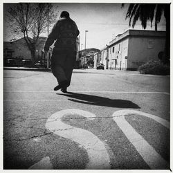 Woman walking on road in city