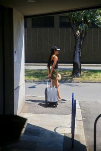 Woman with suitcase on road