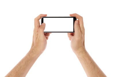 Low section of person holding smart phone against white background