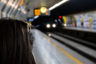 Rear view of woman at railroad station platform