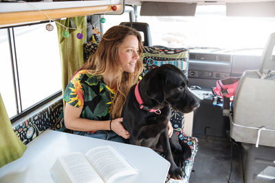 Woman traveling with dog in camper van