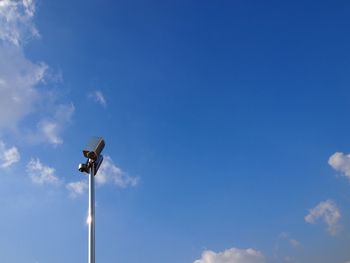 Low angle view of floodlight against blue sky